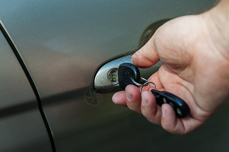 男人的手用钥匙打开车门男性黑色车辆运输安全驾驶汽车水平手指商业图片