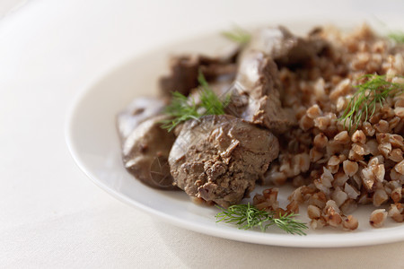 白桌边的炖鸡肝和小麦粥锅油炸乡村饮食食物盘子宏观调色美食谷物香料图片