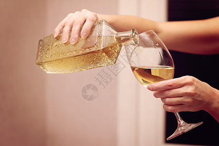 一个女人把酒倒进酒杯里高清图片