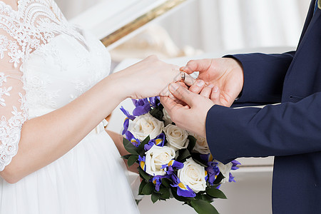 新郎把戒指放在新娘的手上 照片特写套装珠宝女士婚姻妻子交换家庭花束幸福丈夫图片