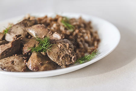 白桌边的炖鸡肝和小麦粥锅美食盘子饮食食物洋葱宏观油炸调色奶油小吃图片