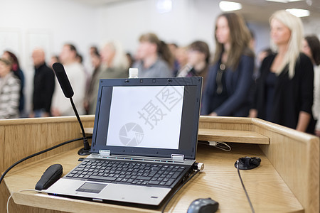 讲台上的讲台上满是会议与会者的演讲厅 有笔记本电脑和麦克风图片