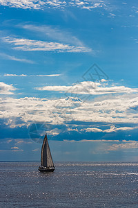 航行中的蓝帆帆船游艇运动船运航海乘客海洋天空运输材料桅杆图片