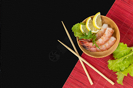 木棍子木板上的虾头饮食专业柠檬盘子台面餐厅树叶美味美食石头背景图片