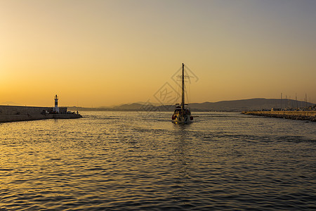 希腊雅典Alimos码头日落时 渔民和帆船巡航航行游客钓鱼旅行旅游闲暇橙子游艇反射图片