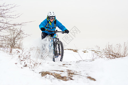 蓝骑山的赛车手在落基温冬山上被雪覆盖 极端运动和概念头盔运动员行动蓝色耐力赛娱乐踪迹山地车爬坡岩石图片