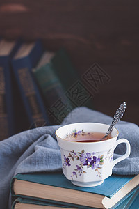 旧书上有茶叶的老瓷杯子咖啡桌子教育早餐饮料阅读笔记木头日记休息图片