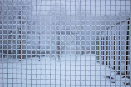 冬季冷冻金属网后面的雪雪运动场炙烤雪花地窖冰柱格子运动雪人院子网格冻结图片