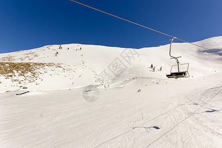 滑雪度假胜地的滑雪电梯白色中心高度蓝色晴天爬坡山顶天空背景图片