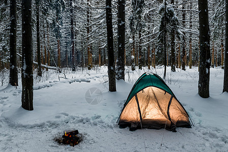 在冬季森林的帐篷里 在燃烧的烈火附近徒步登山图片