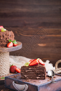 木制背景中带草莓的俄罗斯巧克力蛋糕拿破仑糕点盘子面包薄荷美食咖啡糖果食物甜点烹饪图片