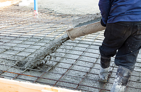 水泥杆在加固金属棒块的罐体上闭合混凝土铸石水泥承包商工人靴子建设者钢筋工作码头地面质量背景
