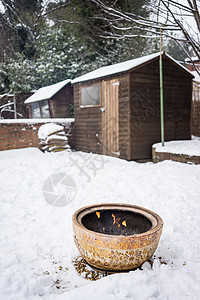 雪中的火碗冻结后院木棚季节花园加热房子冷冻壁炉火坑高清图片