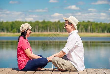 湖边一个木头码头的年轻妻子和丈夫休息图片