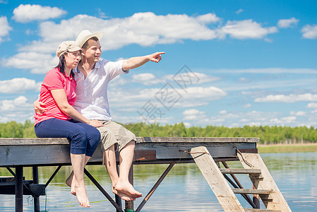 30岁的夫妇在码头休息 男人指着湖图片