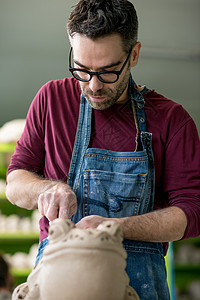 在明亮的陶瓷工作坊里 穿着来自Raw Clay的Apron雕塑肖像用具粘土工具手工业男性工作作坊项目生产工匠图片