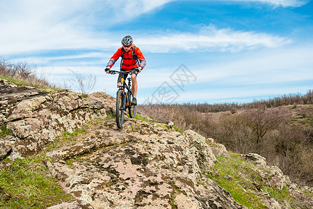 红夹克骑马山下落基山 极端运动和冒险概念的赛车手速度娱乐天空旅行活动骑士爬坡成人男人下坡图片