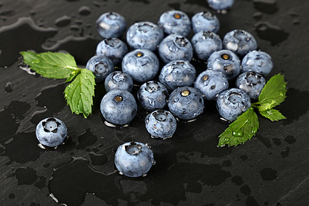 黑板上刚洗过的蓝莓 紧贴黑色石板浆果木板蓝色水果白色烹饪飞沫食物背景图片