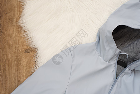 穿蓝色雨衣 戴头罩在木制背景上的妇女蓝雨夹克 时装和设计概念 购物图片