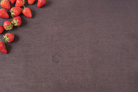 整个新鲜成熟的红草莓的边界排列在左侧 带有复制空间的深色纹理石板背景上 新鲜浆果框架 右侧有复制空间 深色木背景上的草莓图片