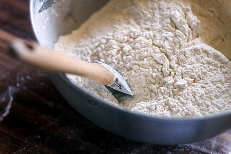 碗里的面粉和黑色木质背景的毛片面包勺子餐巾麸质农业厨房小麦营养桌子烘烤图片