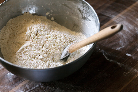 碗里的面粉和黑色木质背景的毛片麸质厨房面包师小麦面团谷物木头餐巾烘烤粮食图片