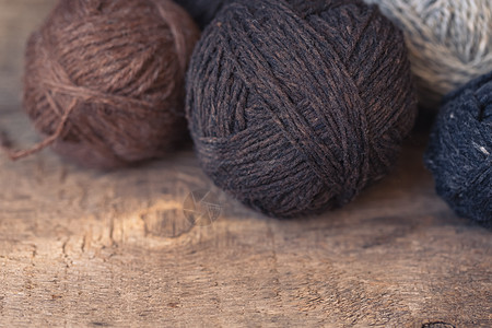质朴的木质背景上的棕色和米色纱球纺织品编织缝纫手工爱好侘寂羊毛木头团体钩针背景图片