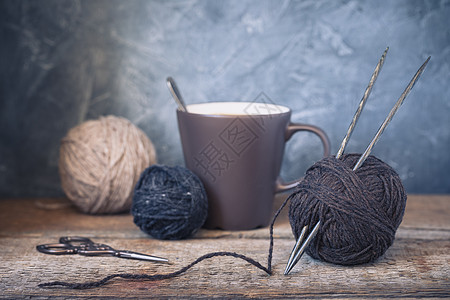 质朴的木质背景上的棕色和米色纱球棉布工艺侘寂纤维缝纫织物编织手工业爱好羊毛背景图片