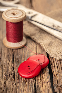 带纽扣和剪刀的红线针线活工具裁缝工作纺织品筒管线程剪裁按钮棉布图片