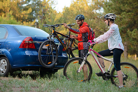 冒险与家庭旅行概念 由Bike Rack在汽车上搭乘的  年轻夫妇脱身山车松树耐力赛站立运动员车辆架子女性夫妻男性娱乐图片