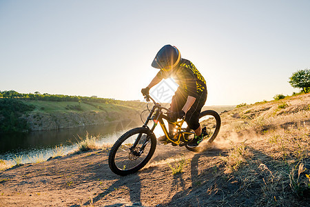 赛车手骑着山上摩托 在夏日落石轨的夜晚 极端运动和Enduro自行车概念爬坡男性踪迹活动乐趣耐力赛漂移天空速度下坡图片