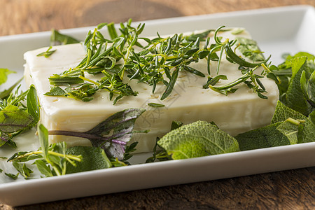 用草药将一块 feta 奶酪配上乡村美食百里香叶子食物白色小吃盘子木头图片