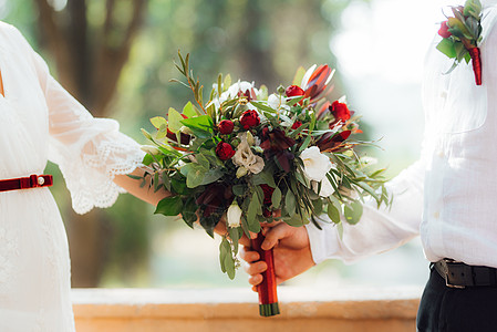 女人和玫瑰红花和绿绿色的鲜红色花束女孩女士仪式婚姻裙子庆典乡村新娘花朵婚礼背景