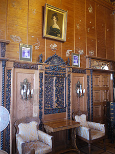 庄园内有女性肖像和装饰精美的木墙的房间图片