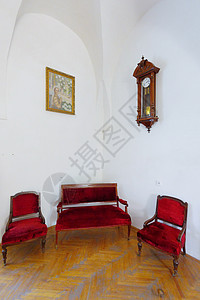 红色沙发和两把手扶椅及古董时钟图片