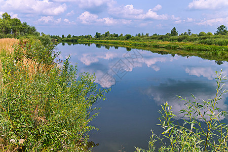 两个绿色海滩之间 蓝色透明河流的风景 与云层天空背景相交 图案图片