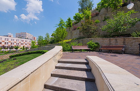 通往一个带长凳的小广场的台阶和一堵有几层绿色空间的墙图片