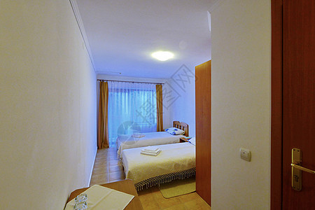 一个清洁的小型旅馆房间 配有双床和大窗户图片