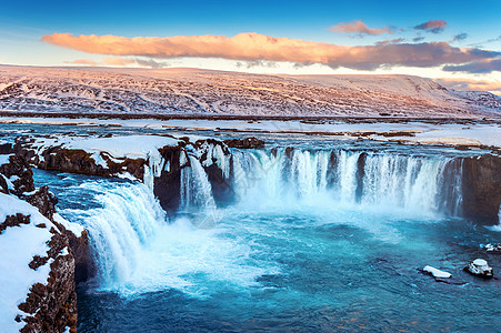 冰岛冬季日落时的戈达福斯瀑布冰川流动岩石戏剧性天空蓝色旅游美丽溪流运动图片