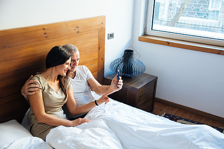 在床上放松的情侣成人微笑头发卧室夫妻妻子男性已婚枕头家庭图片