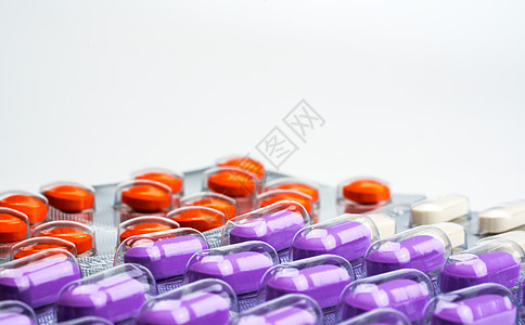 白色背景泡罩包装中橙色紫色和白色药丸的宏观拍摄细节 五颜六色的止痛药  NSAIDs 类抗炎药可引起胃溃疡 医药包装行业 药房背图片