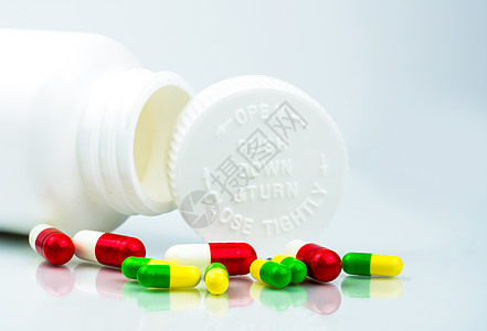白色背景上的彩色药丸和带有空白标签和复制空间的塑料瓶 儿童保护包装 防儿童药盒 向下推并转动盖子 全球医疗保健概念 医药包装行业图片