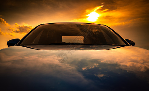 蓝色紧凑型 SUV 汽车 具有运动 现代和豪华的设计 日落时分停在海边的水泥路上 美丽的混合动力车在橙色天空和云彩背景下的前视图图片