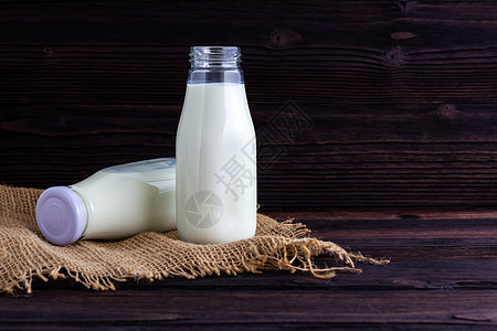 木制背景的牛奶瓶食物玻璃桌子早餐奶制品奶油白色营养图片