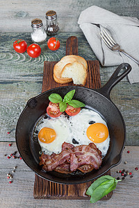早餐生菜式的早餐熏肉平底锅午餐餐巾桌子蛋黄香料煎锅蔬菜胡椒图片