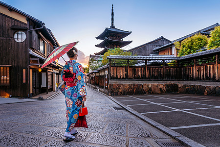 在日本京都的和Sannen Zaka街 妇女带着雨伞穿着日本传统和服寺庙地标神道文化景观街道神社宝塔城市地区背景图片