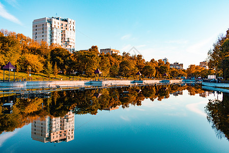 俄罗斯哈巴罗夫斯克Khabarovsk  2018年9月27日 秋季的城市池塘旅行建筑学反射水域岩石木头市中心风景建筑蓝色图片