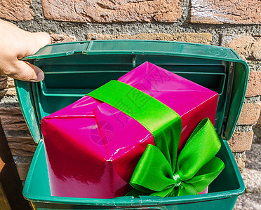 粉红色的大圣诞礼物 带丝带的是经典的绿色邮筒背景图片