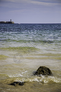 桑迪带石头的海滩岩石太阳日落海岸卵石海岸线蓝色海景天空鹅卵石图片