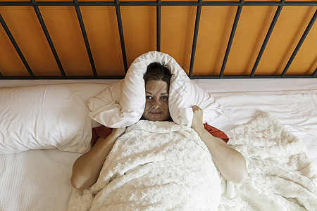 带着枕头睡床上的年轻妇女寝具白色警报成人女孩毯子就寝时间睡眠女性图片